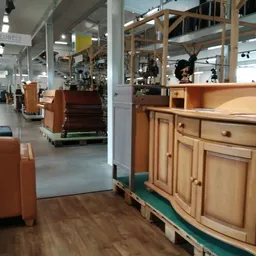 Winkelvloer met meubels zoals kasten en fauteuils, stellingen en toonbanken in een kringloopwinkel