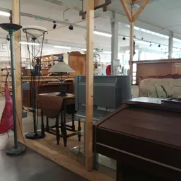 Winkelvloer met houten stellingen waarin meubels en huishoudelijke spullen zijn uitgestald