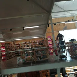 Overzicht van de winkelvloer met boekenrekken, roze decoratie en uitgestalde spullen onder daklicht