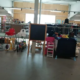 Winkelvloer met diverse speelgoed en kinderartikelen, stellingen met kleding op de achtergrond