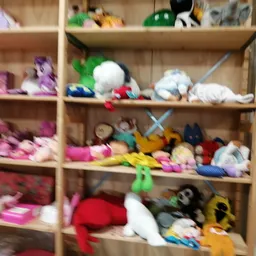 Houten stellingen vol met knuffels, speelgoed en textiel in verschillende kleuren