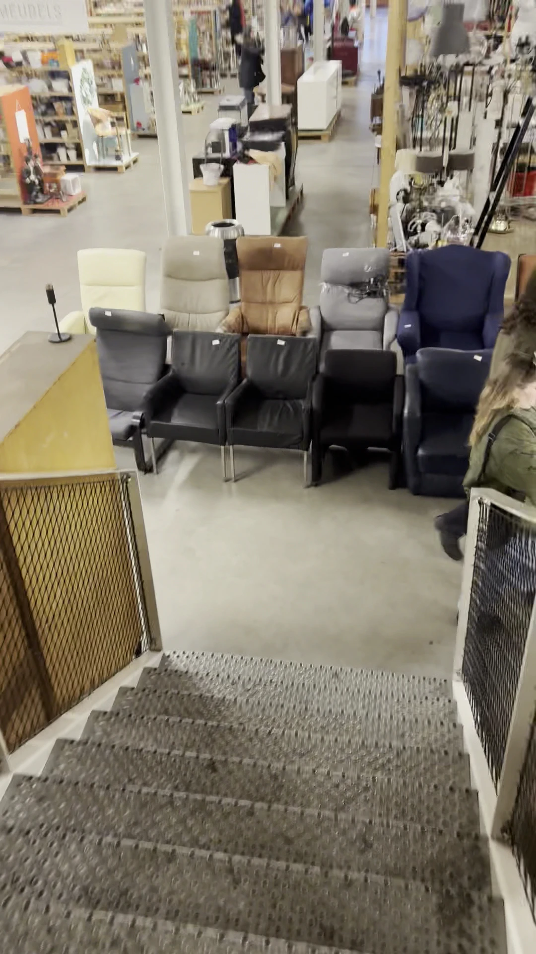 Zwarte leren stoelen en fauteuils in een winkelruimte met grijs linoleum