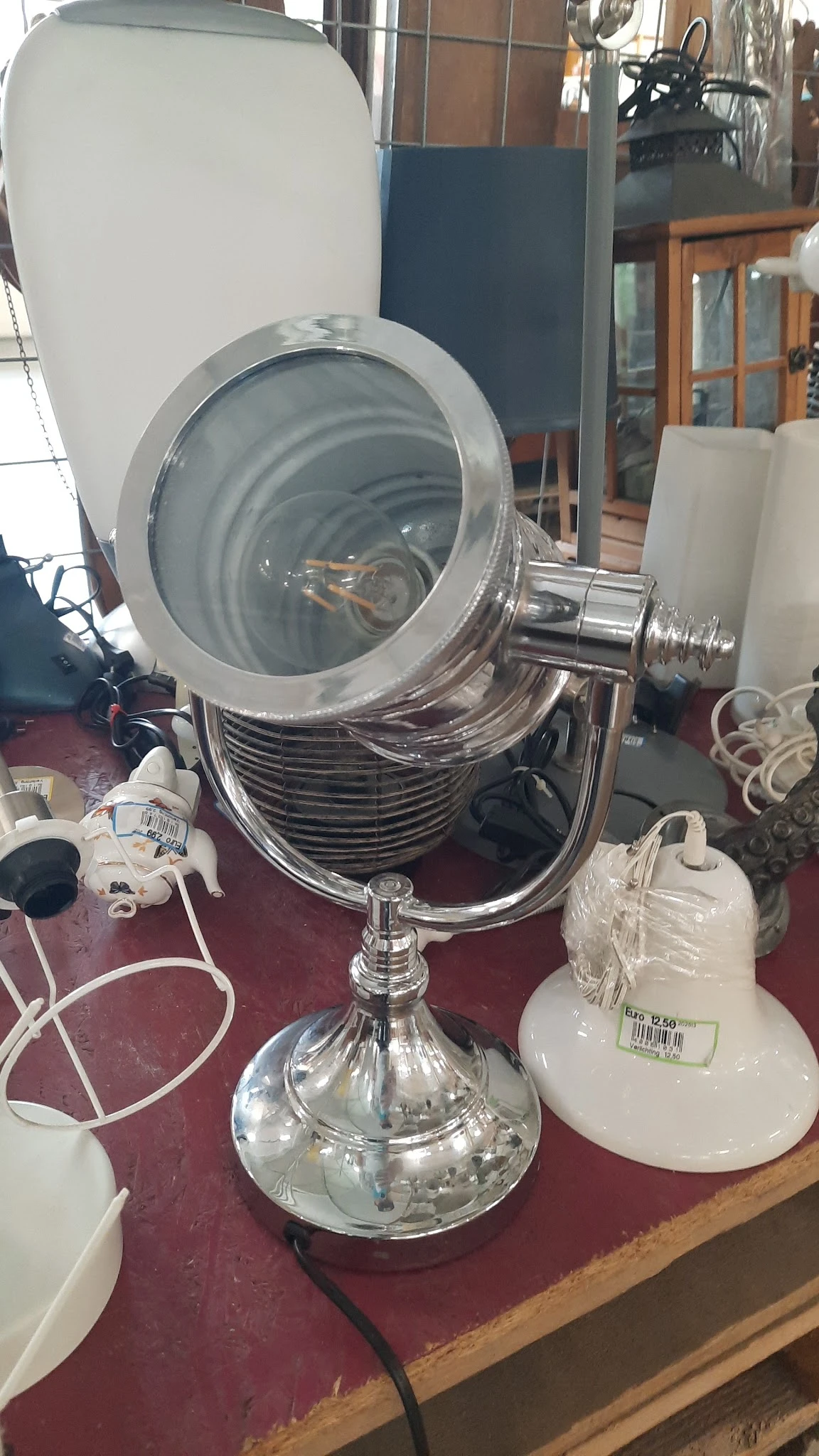 Grote zilverkleurige spotlamp of schijnwerper op standaard met geelgroene glazen lens