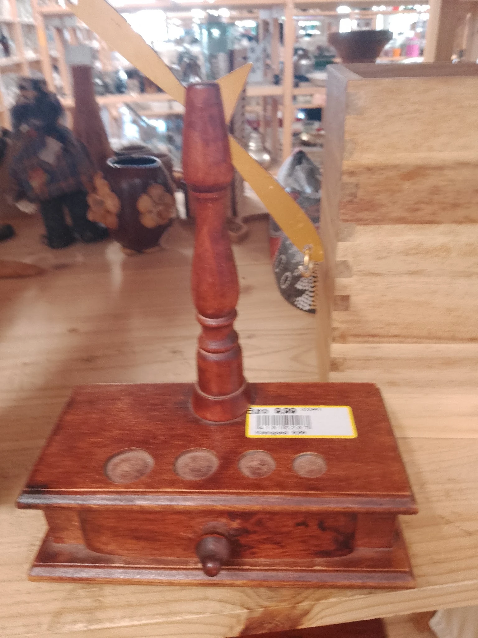 Houten standaard met rode decoratieve paal en vier ronde uitsparing in het blad