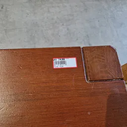 Closeup van een houten meubelstuk met prijssticker