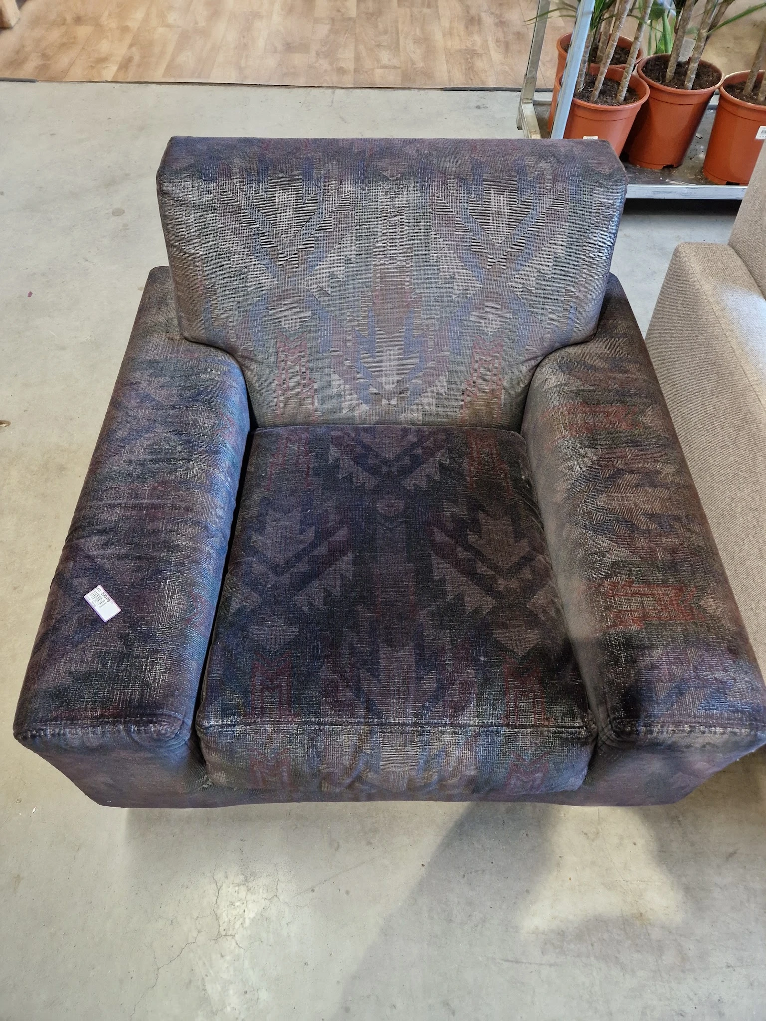 Grijze/paarse tweedehands fauteuil met armleuningen, gefotografeerd van bovenaf
