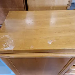 Houten dressoir of ladekast met zichtbare vlekken en beschadigingen op het oppervlak