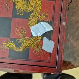Rood decoratief paneel met gouden drakenafbeelding, gedeeltelijk bedekt met witte doeken