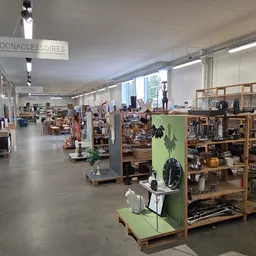 Ruime winkelvloer met houten stellingen vol tweedehands spullen en artikelen