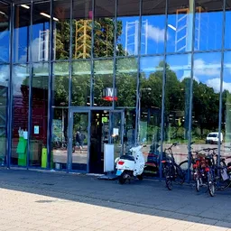 Glazen gevel van kringloopwinkel met fietsen geparkeerd voor de ingang