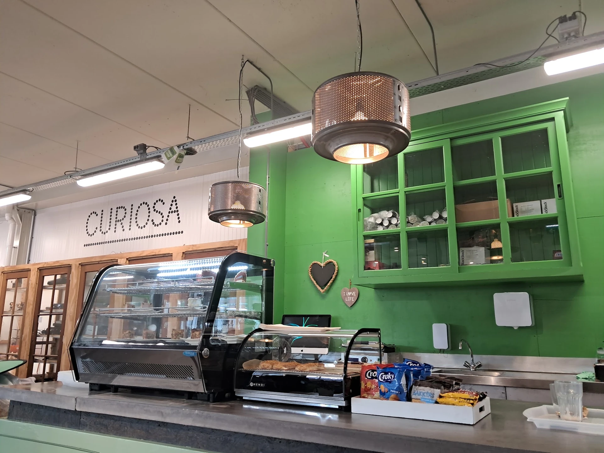 Toonbank met displaykasten en groene kastenwand in een winkelinterieur