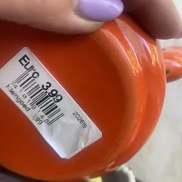 Close-up van een oranje plastic container met prijssticker en barcode