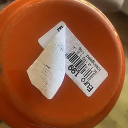 Twee prijsstickers of etiketten op een oranje oppervlak
