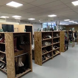 Houten stellingen met tweedehands schoenen en tassen in verschillende vakken