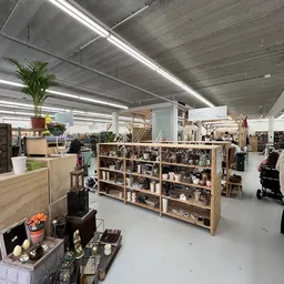 Winkelvloer met houten stellingen vol spullen, kasten en displays in een grote heldere ruimte