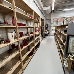 Houten stellingen met huishoudelijke artikelen en decoratie in een kringloopwinkel