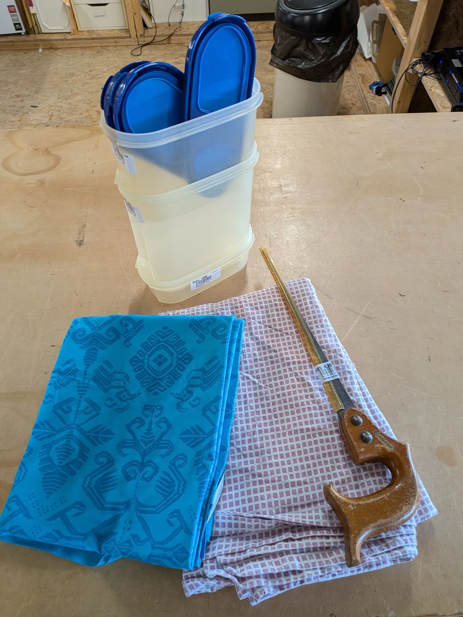 Close-up van huishoudelijke artikelen: blauwe doek, paarse doek, houten lepel en plastic container met water