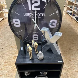 Wandklok van Union Hotel Parijs met decoratieve figuren op de basis