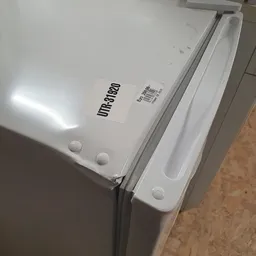 Bovenkant van een witte koelkast met het merk 'Umbro80' en een barcode-etiket