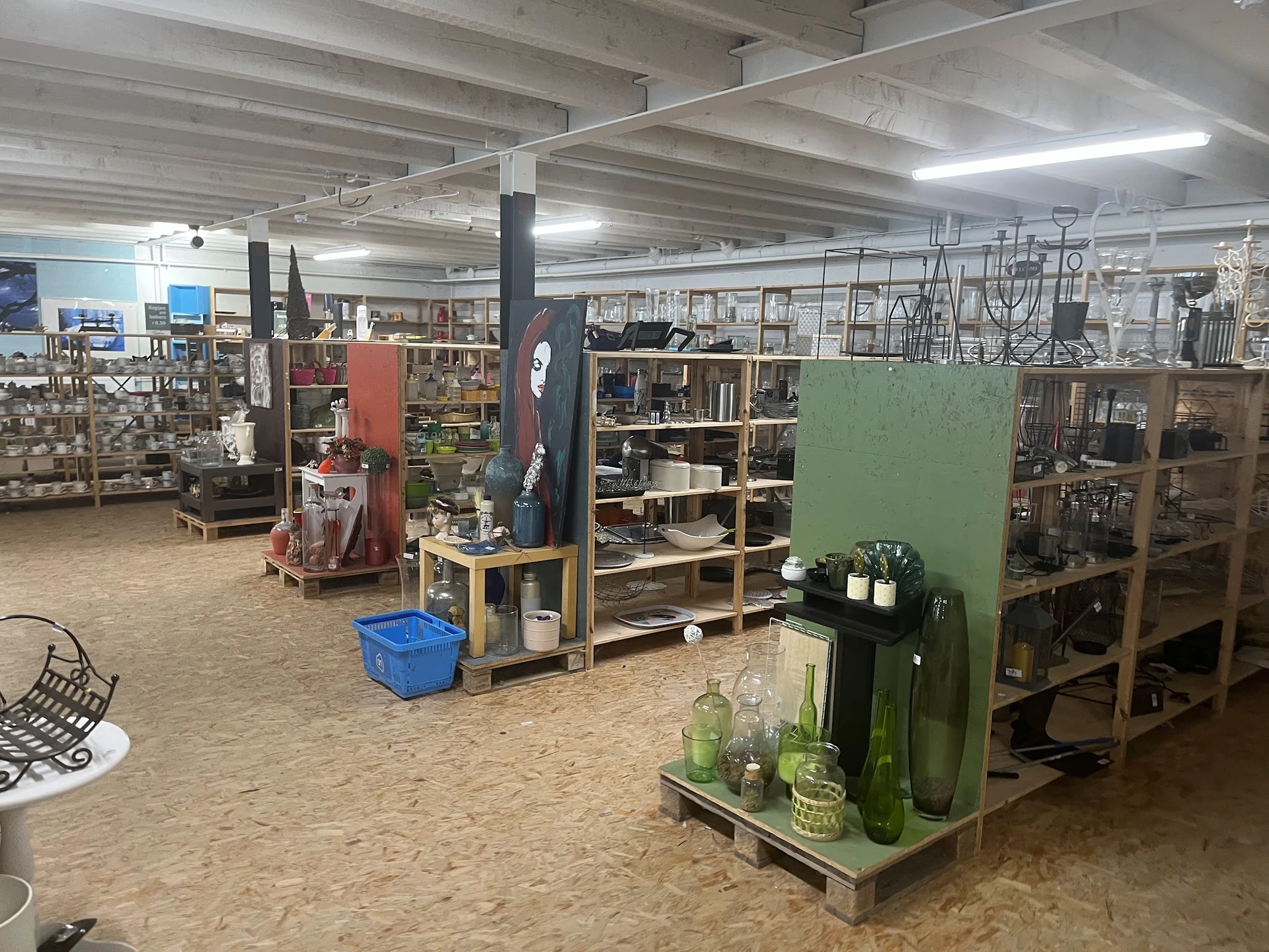 Winkelvloer met stellingen en display-eilanden met huishoudartikel en decoratie in kringloopwinkel