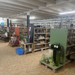 Winkelvloer met stellingen en display-eilanden met huishoudartikel en decoratie in kringloopwinkel