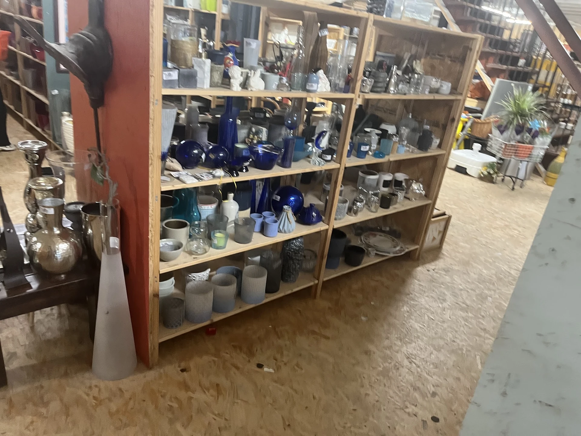 Houten stellingen met huishoudelijke artikelen en serviesgoed in verschillende kleuren