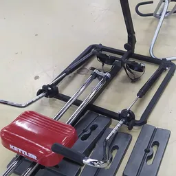 Close-up van een rode en zwarte fietsdrager met stuurbeugels en montagebeugels