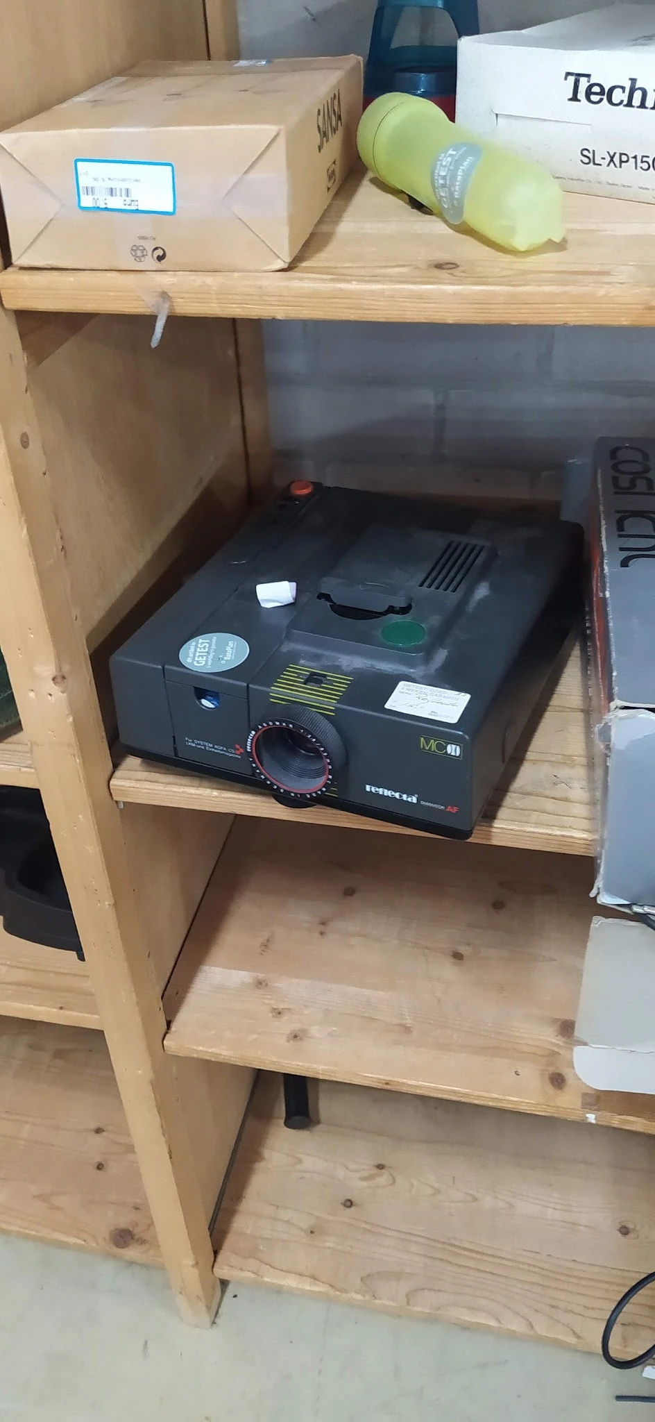 Zwart vintage fototoestel met draaiknop op houten plank in kast