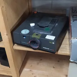 Zwart vintage fototoestel met draaiknop op houten plank in kast