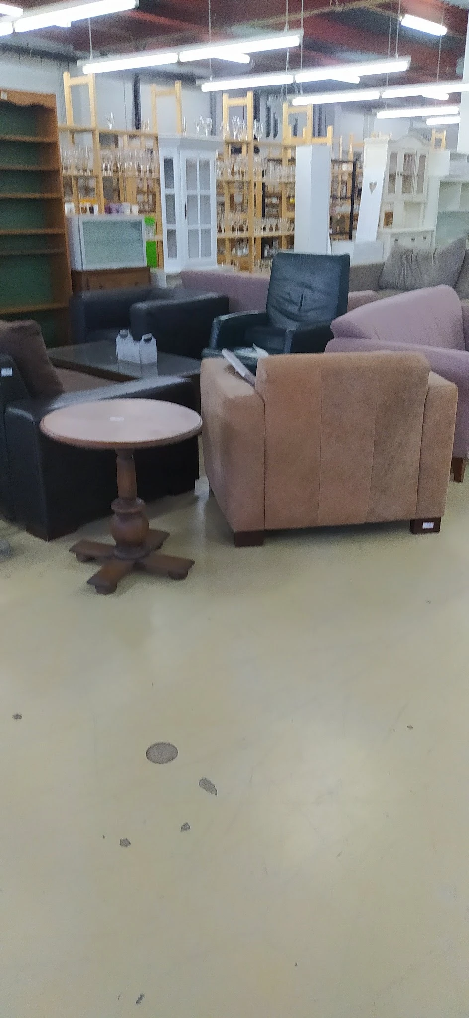 Bruine fauteuil en ronde houten bijzettafel in de kringloopwinkel