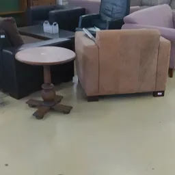 Bruine fauteuil en ronde houten bijzettafel in de kringloopwinkel