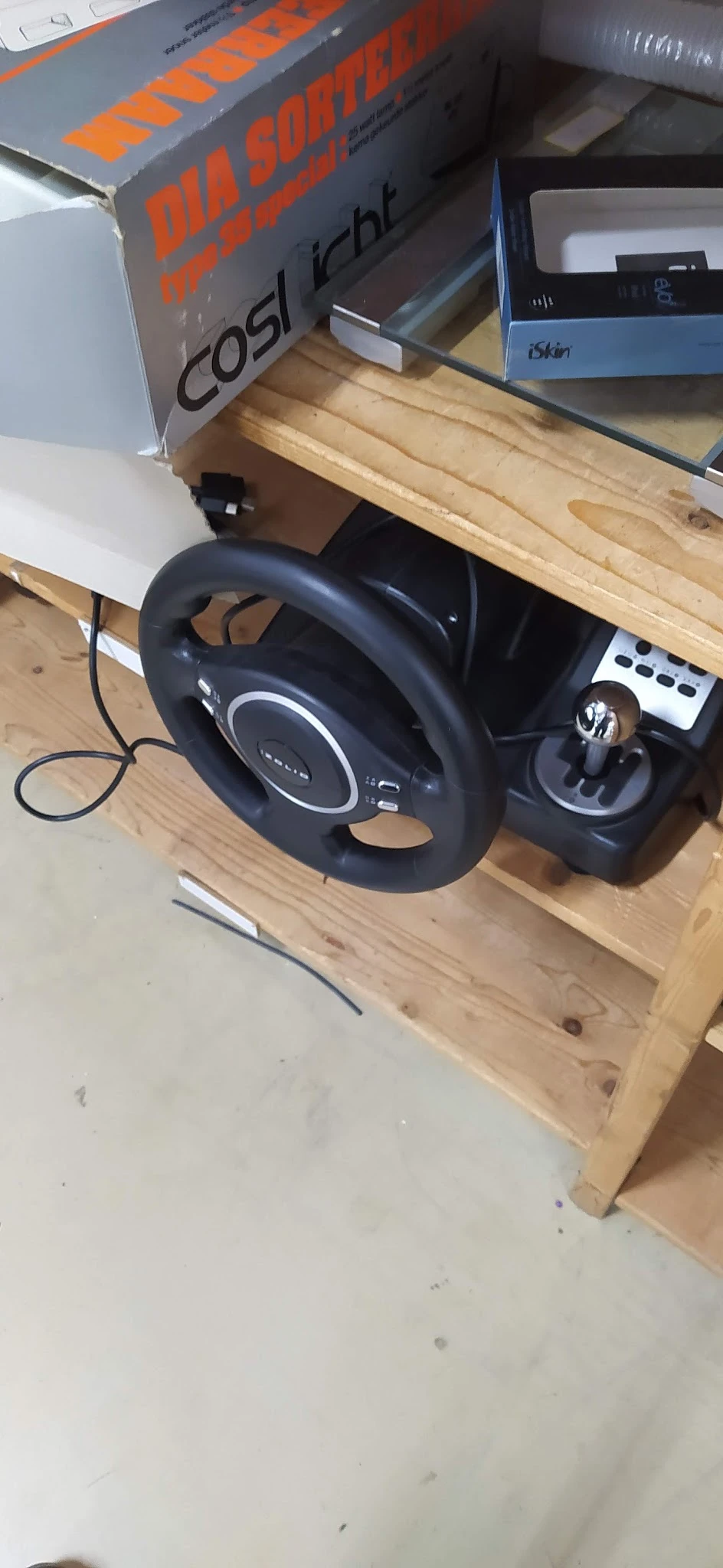 Zwart gaming stuurwiel met pedalen en versnellingsbak op houten plank