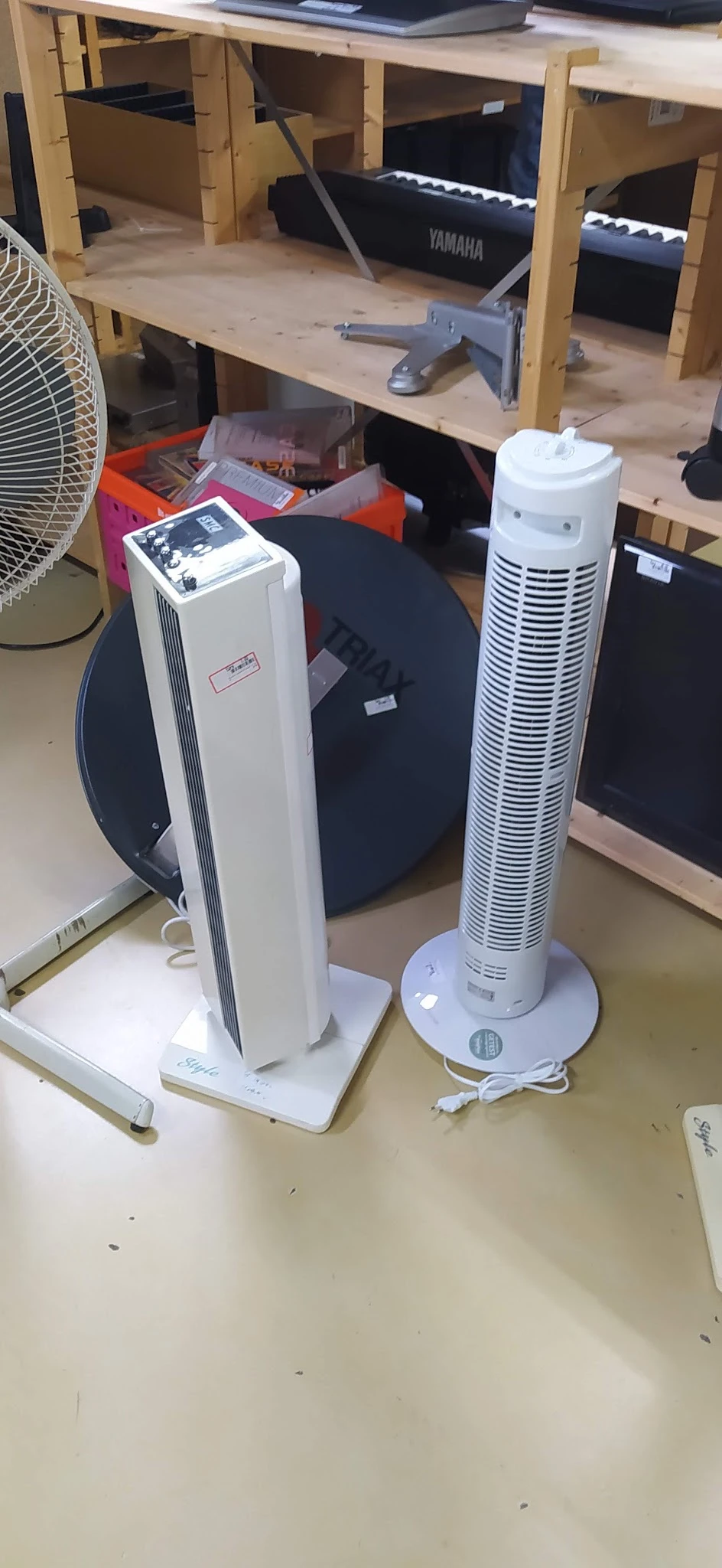Twee staande ventilatoren en andere elektrische apparaten op een tafel in de winkel