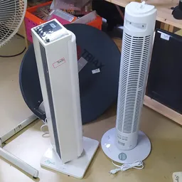 Twee staande ventilatoren en andere elektrische apparaten op een tafel in de winkel