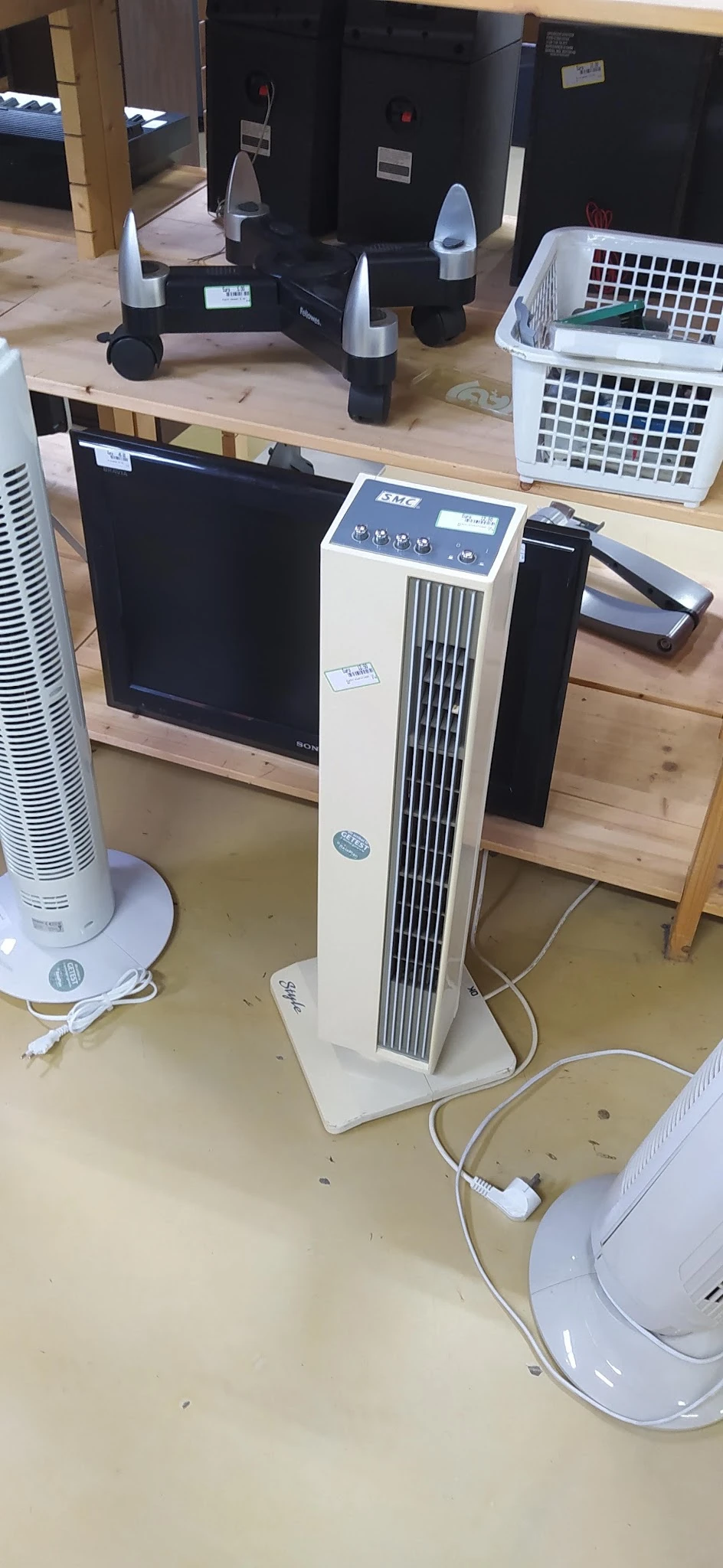 Witte verticale airconditioner of luchtreiniger met zwarte ventilatiesleuven op winkelvloer