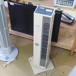 Witte verticale airconditioner of luchtreiniger met zwarte ventilatiesleuven op winkelvloer