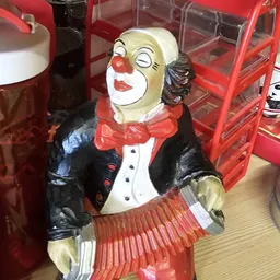 Decoratief clownfiguur met rood neus, rode strik en zwart jasje met witte shirt