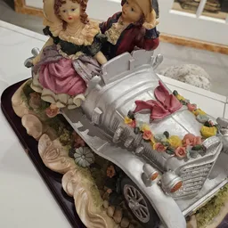 Decoratief artikelenset met een zilveren auto-vormige spaarpot versierd met bloemen en lint