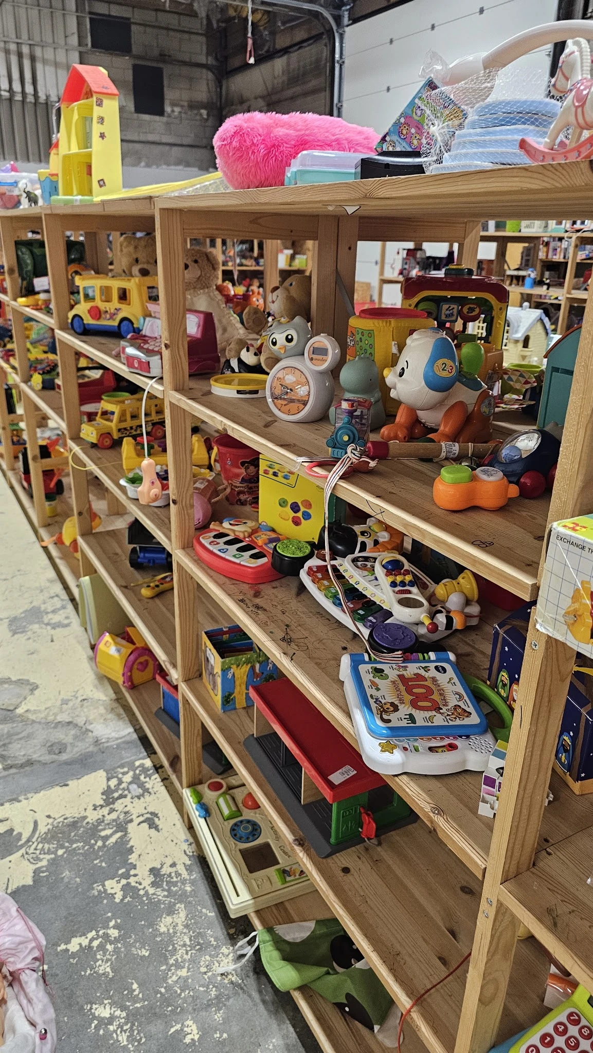 Houten stellingen met speelgoed: robotten, auto's, speelgoed figuren en educatief speelgoed.