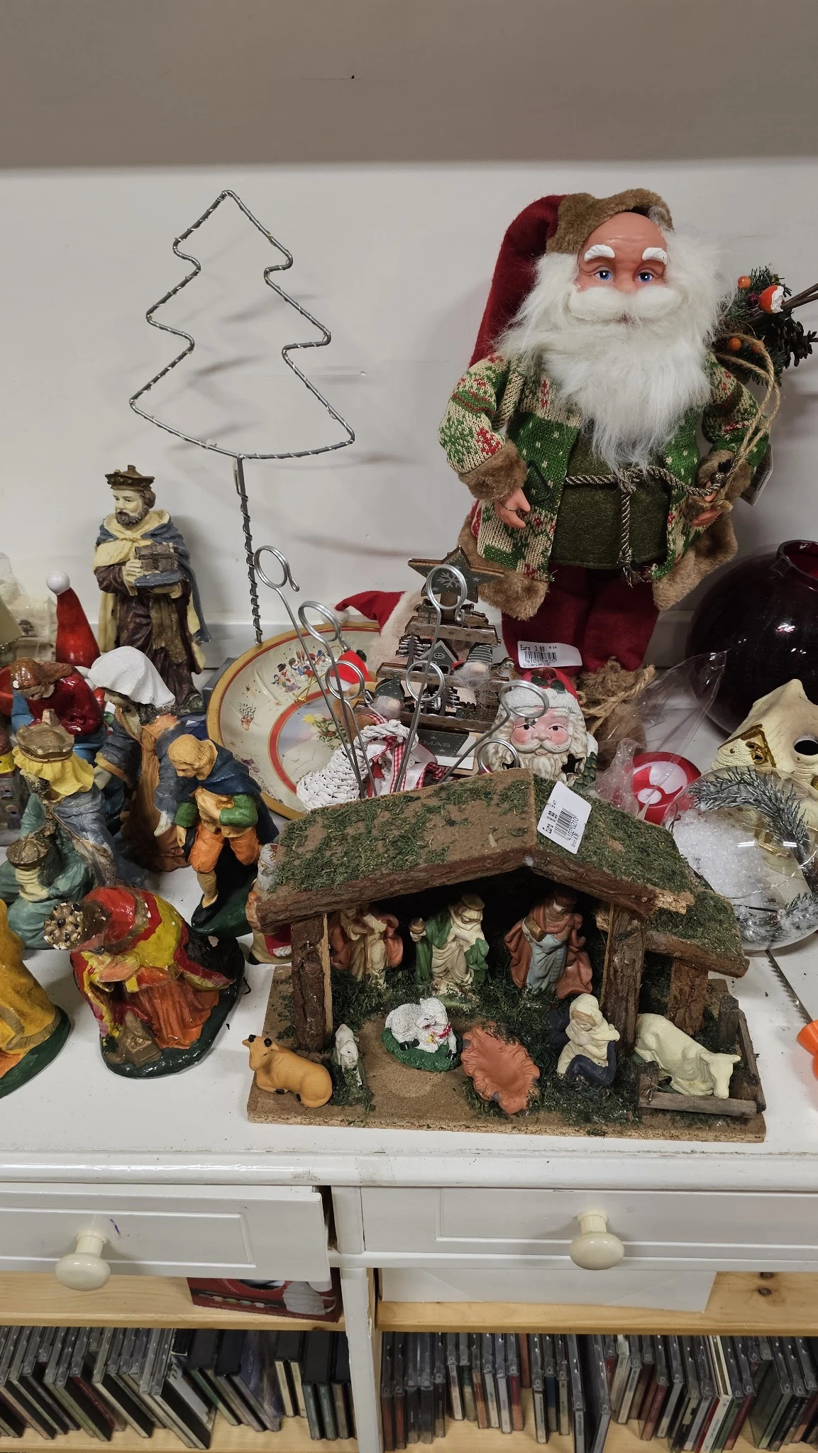 Uitgestalde religieuze beeldjes, kruisifixen, kerststalletjes en decoratieve artikelen in de kringloopwinkel