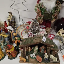 Uitgestalde religieuze beeldjes, kruisifixen, kerststalletjes en decoratieve artikelen in de kringloopwinkel