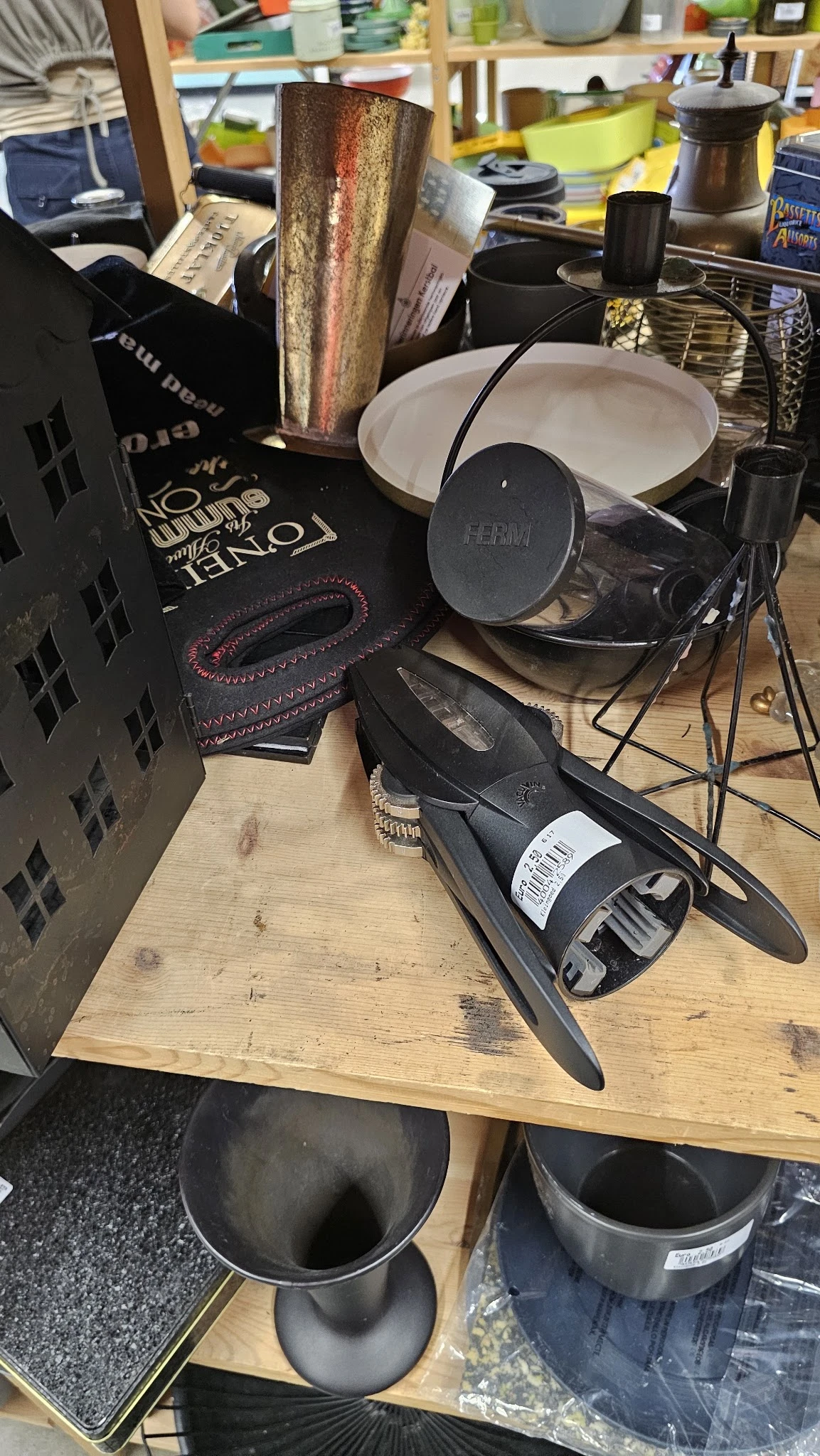 Close-up van een zwarte microfoon met witte label op houten tafel, met boeken en ander audiogereedschap op de achtergrond