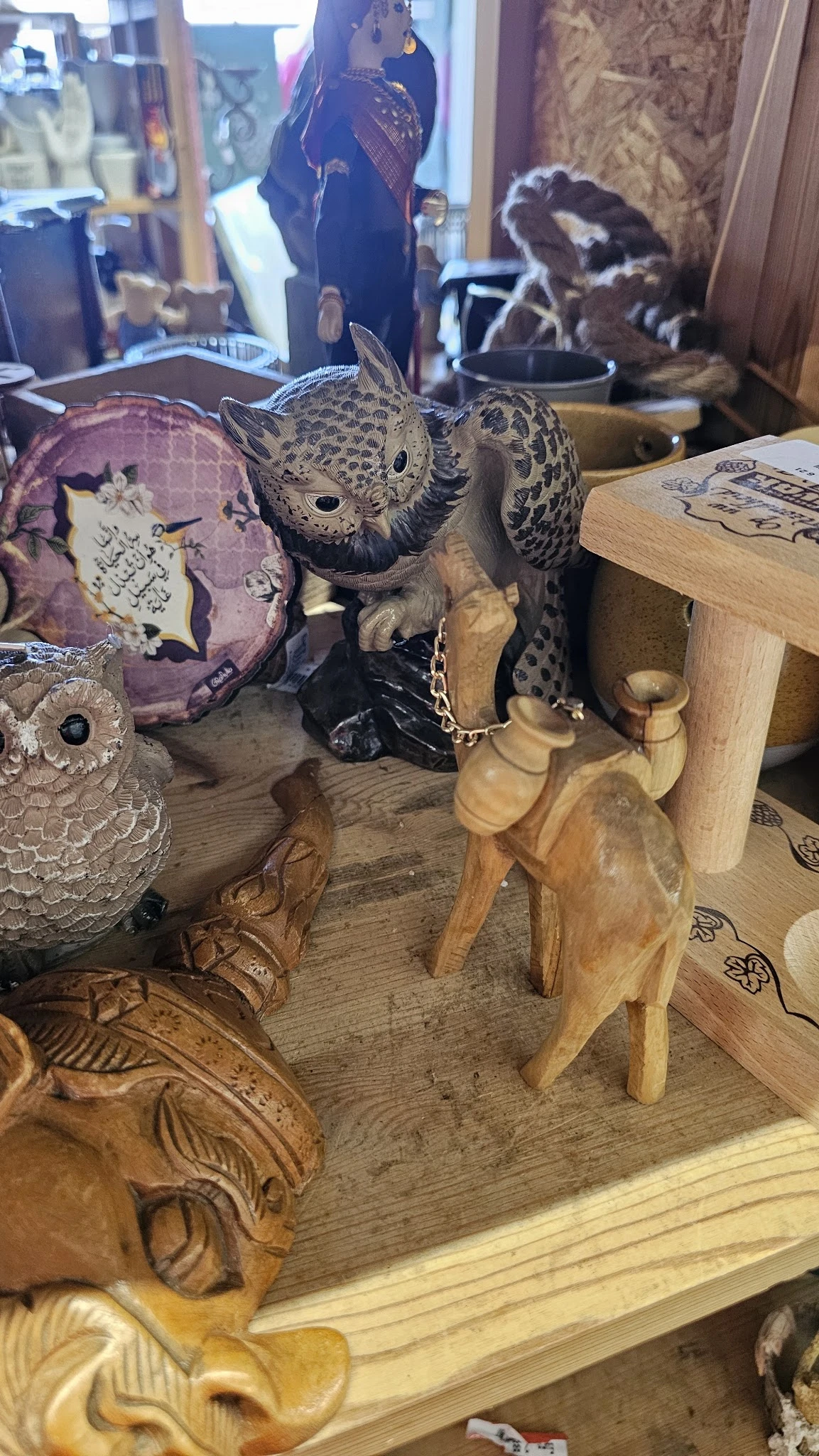 Houten beeldjes en decoratieve uilen op een tafel in de winkel