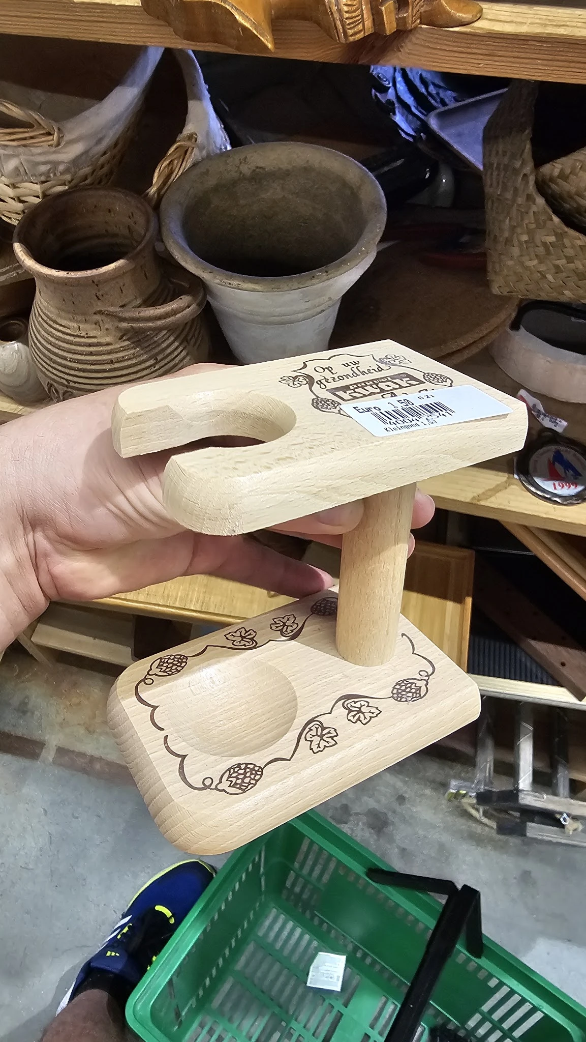 Houten speelgoedstaander met gat voor bal, voorzien van decoratieve brandwerk, wordt in hand gehouden