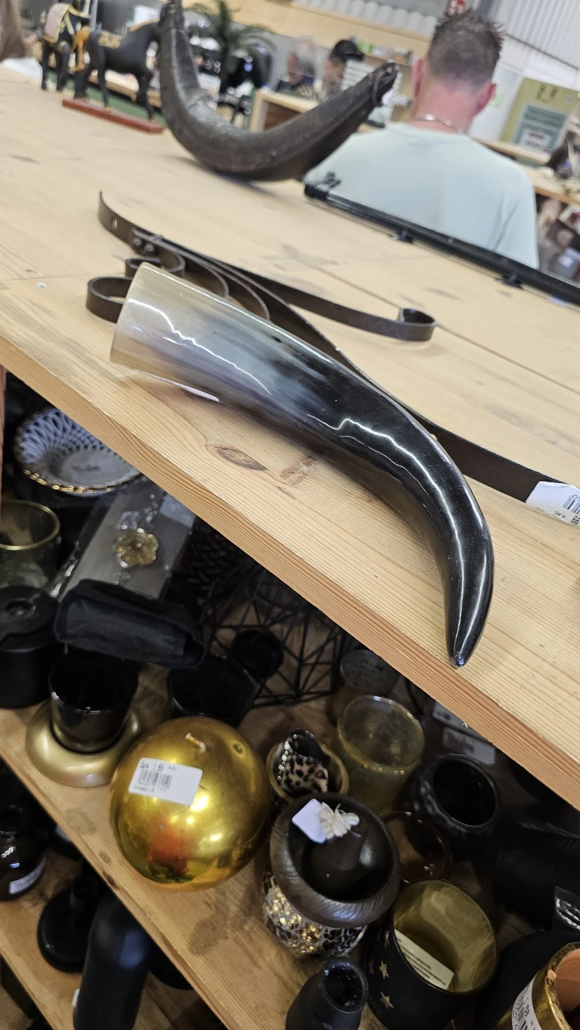 Close-up van een zwart glanzend decoratief object met golvende vormen op houten tafel