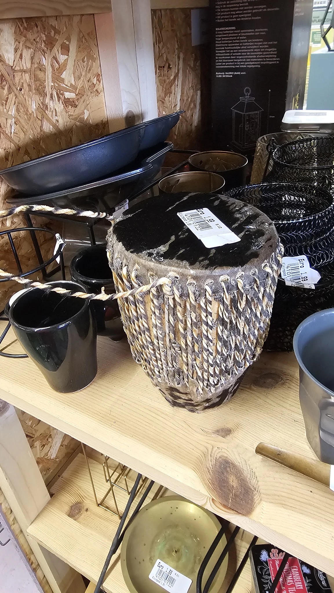 Diverse huishoudelijke items op een tafel, waaronder manden, zwarte emmers en andere opbergartikelen