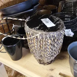 Diverse huishoudelijke items op een tafel, waaronder manden, zwarte emmers en andere opbergartikelen