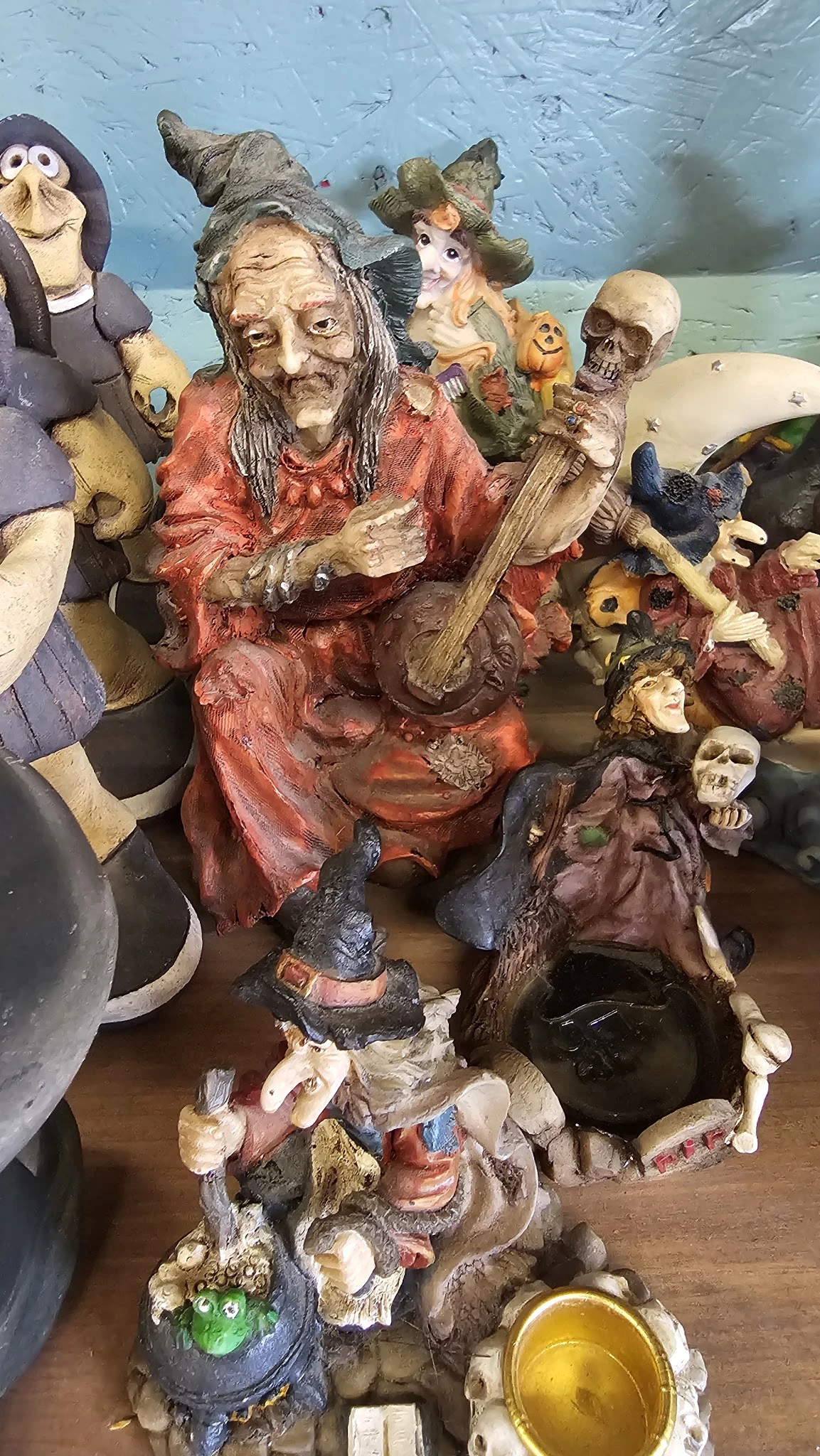 Verzameling decoratieve beelden en figuren met muziekinstrumenten, waaronder rood en bruin gekleurde religieuze of traditione