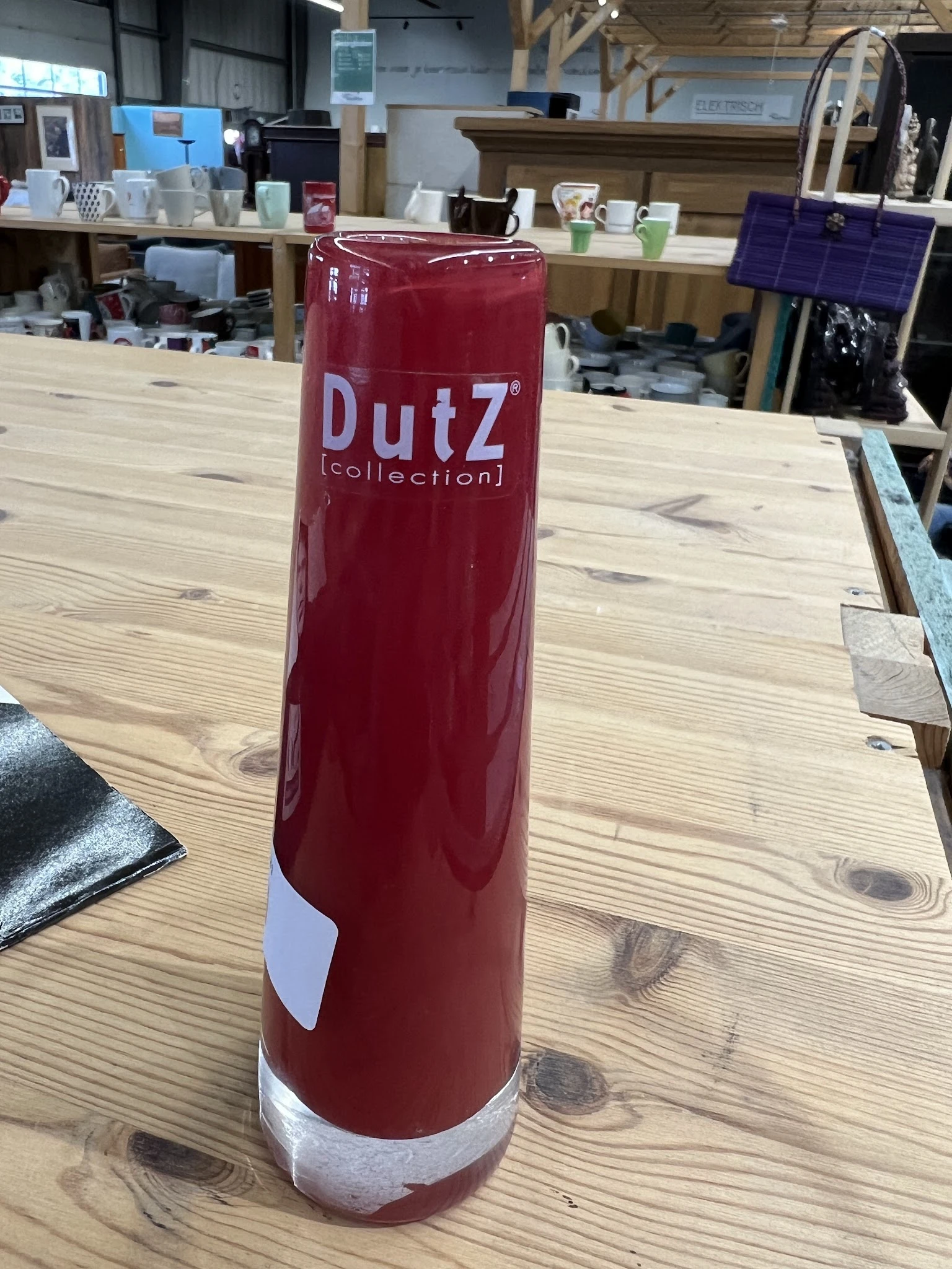 Rode DutZ collection vaas op houten tafel in winkel