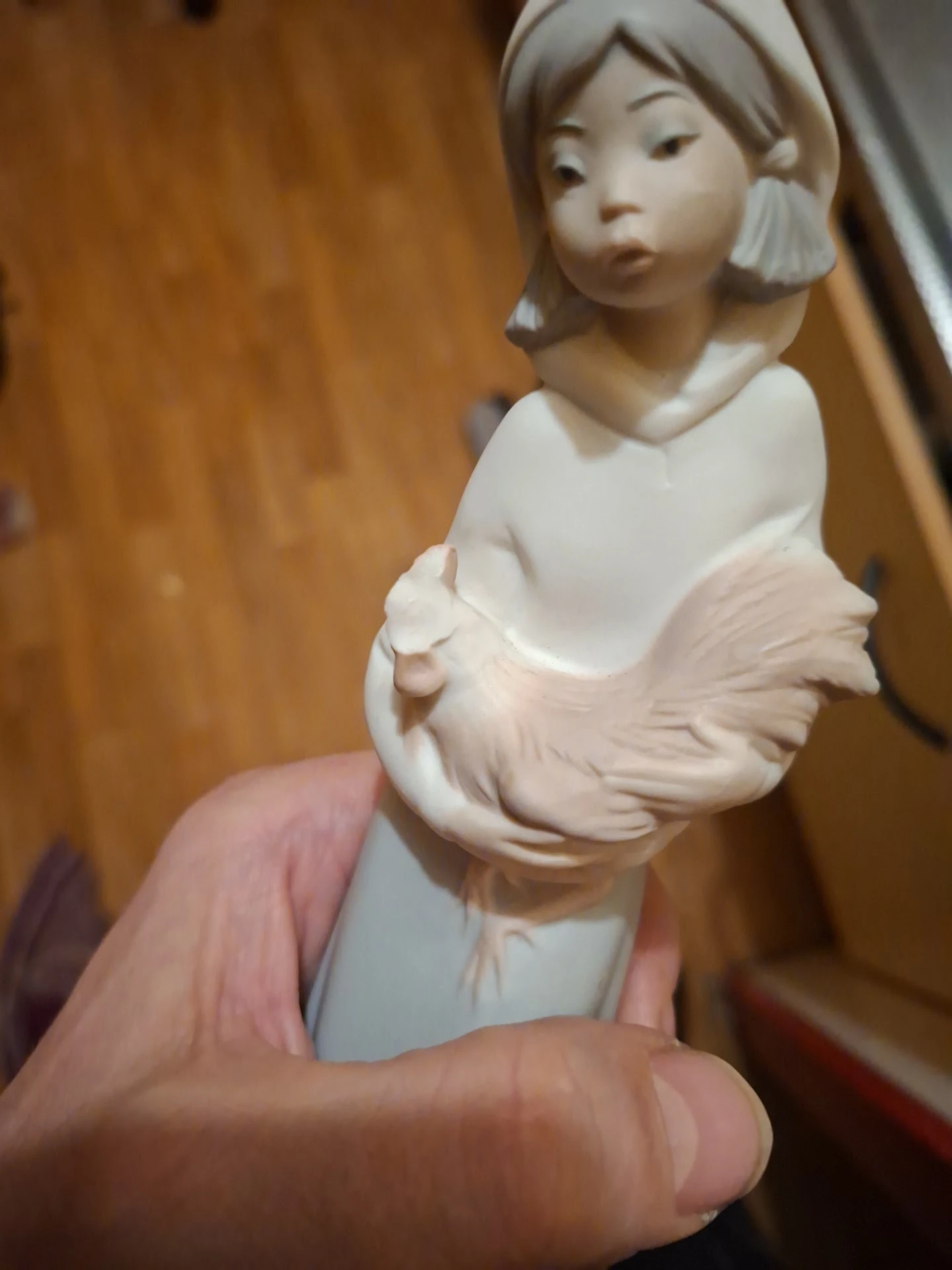Close-up van een wit porseleinbeeldje van een vrouw in roze jurk
